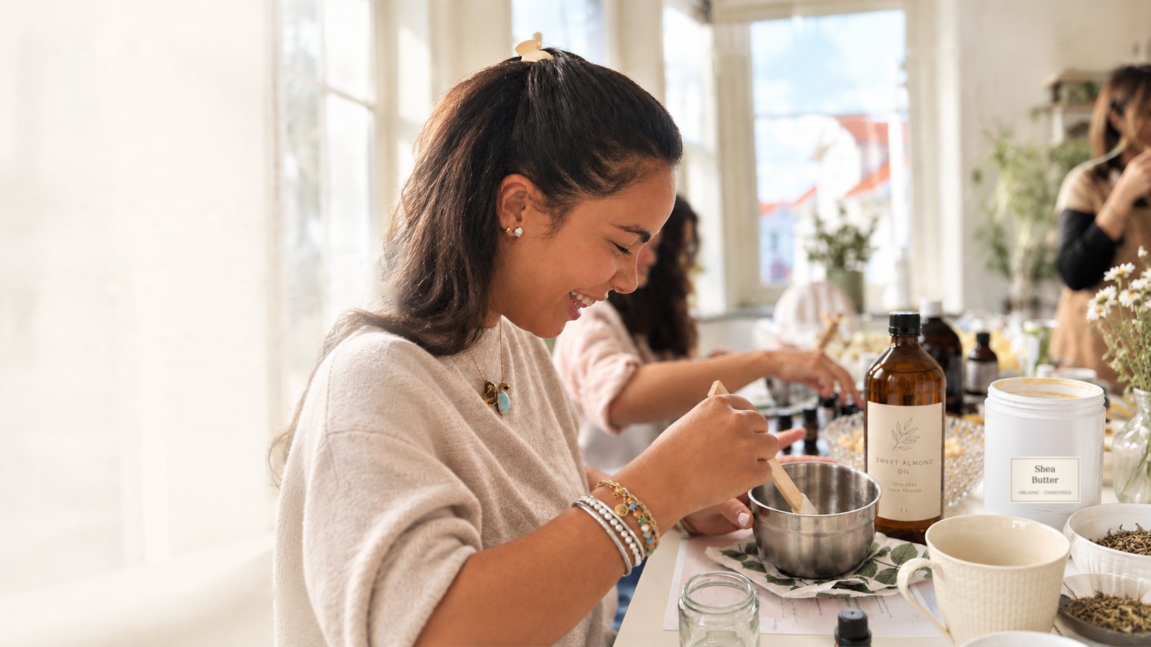 A smiling woman stirring a bowl of her own natural skincare at a Nosara gathering